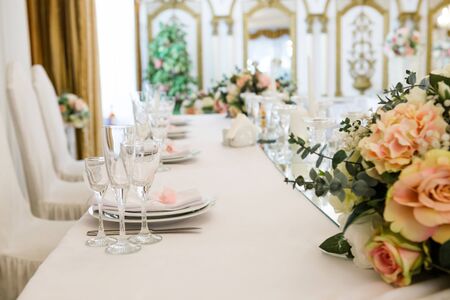 Table served for newlyweds dinner in luxury restaurant. White candles, cutlery on mirror,...