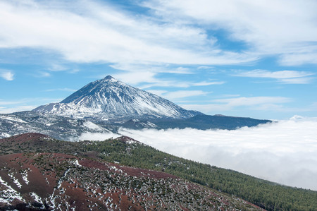 Volcanic mountain with snow and  cloudy blue skyの写真素材