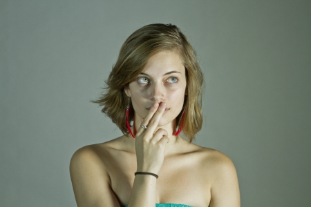 Thinking Young Woman With Two Fingers on Mouthの写真素材