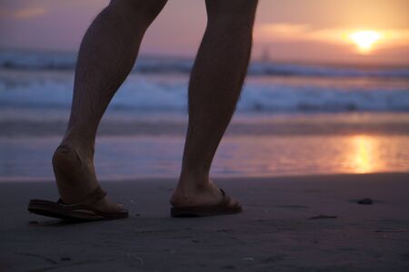 Walking Feet on a Beach Sunsetの写真素材