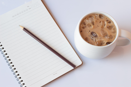 Open a blank white notebook, pencil  and iced coffee isolate on white background.の写真素材