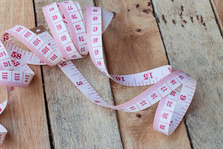 tape measuring  on a wood backgroundの写真素材