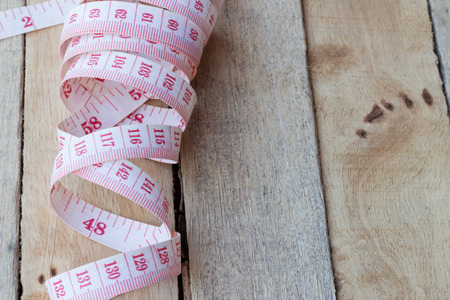 tape measuring  on a wood background