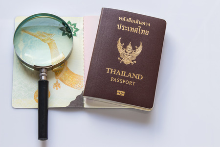 Magnifying glass and passport Thailand on white background.の写真素材