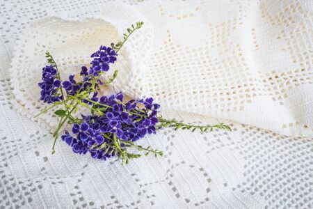 Purple flowers on a white tablecloth.の写真素材