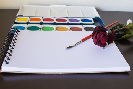 Painting equipments and  dry rose  on wood background.の写真素材