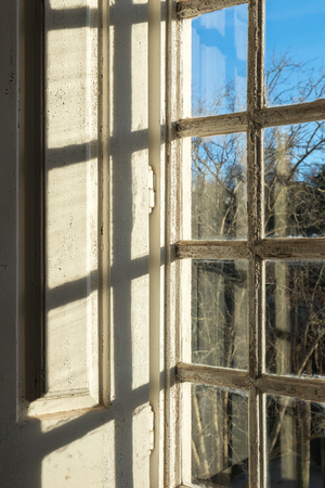 one of the old windows made of wood and paitend in white in Mafra monastery facing the royal gardensの写真素材