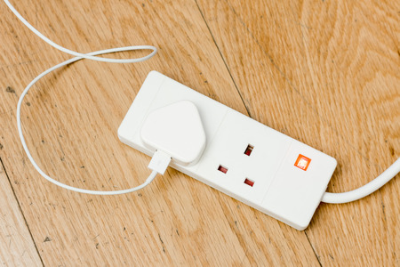 A white plastic extension power cord from united kingdom. One cable attached to it.の写真素材