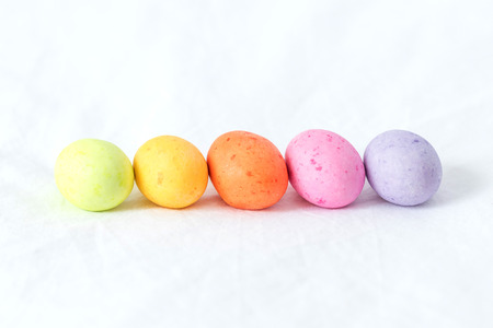Spring colorful easter eggs sitting in a white sheet all in a horizontal line