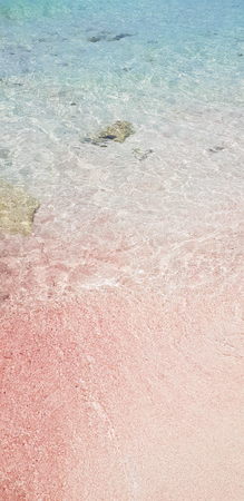 Full frame cristal clear water in a beach with pink sand at shoreの写真素材