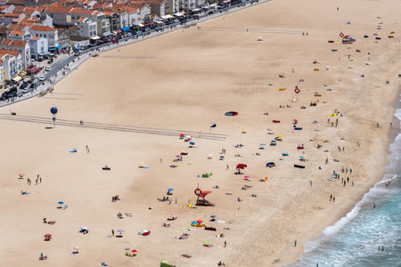 High view on many people at the sand of the beach close to the city seen from above, during a sunny summer dayの写真素材