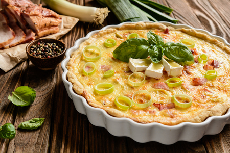 Traditional French Quiche Lorraine with Cheddar, Camembert, bacon and eggsの写真素材