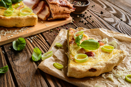 Traditional French Quiche Lorraine with Cheddar, Camembert, bacon and eggsの写真素材