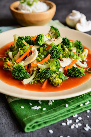 Vegetarian steamed broccoli salad with mushroom, carrot and onion, served with tomato sauce and riceの写真素材