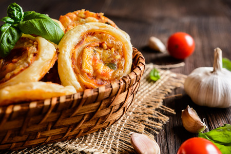 Baked puff pastry rolls stuffed with tofu, mozzarella, tomato sauce, garlic and basilの写真素材
