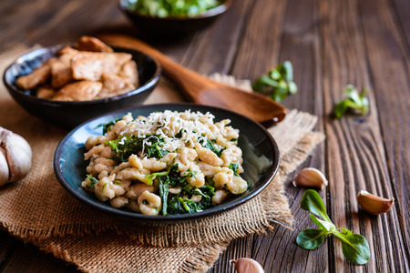 Fried chicken breasts pieces with spelt flour dumplings and steamed spinachの写真素材
