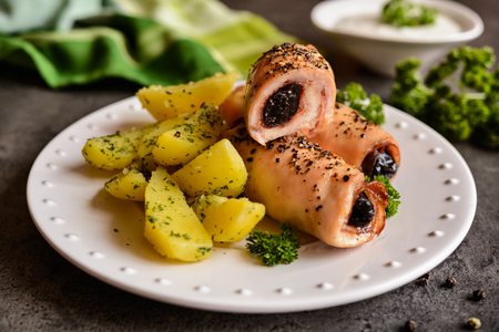 Roasted chicken breasts chops stuffed with bacon slices and dried plum, garnished with potatoの写真素材