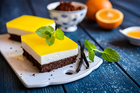 Delicious chocolate cake bars with mascarpone layer and orange jelly toppingの写真素材