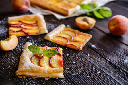 Delicious puff pastry pie topped with sliced peachの写真素材