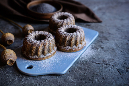 Delicious small poppy seeds bund cakes with powdered sugar icingの写真素材