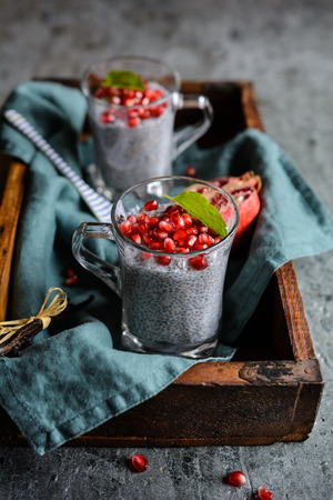 Raw chia pudding with pomegranate seeds in glass jarsの写真素材