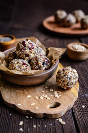 Healthy raw oatmeal balls with chia seeds, dried cranberries, grated coconut, flax seeds and honeyの写真素材