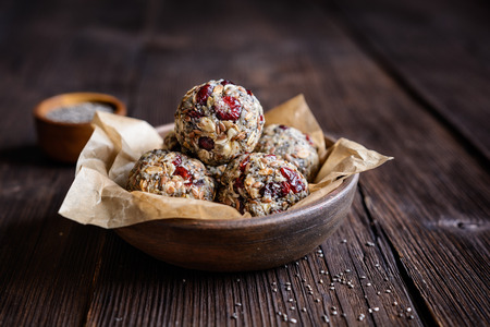 Healthy raw oatmeal balls with chia seeds, dried cranberries, grated coconut, flax seeds and honeyの写真素材