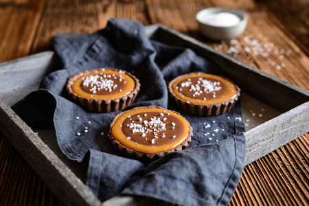 Homemade chocolate caramel tartlets studded with saltの写真素材