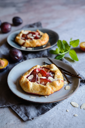 Traditional mini plum galettes with almond slicesの写真素材