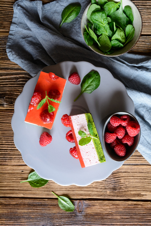 Sweet spinach cake with raspberry mousse and layer of jelly, decorated with fresh mintの写真素材