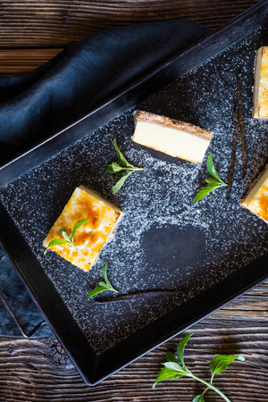 Homemade Creme Brulee cheesecake bars with cream cheese, crushed cookies, topped with caramelized sugarの写真素材