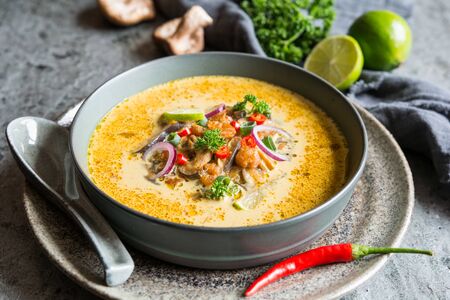 Delicious Thai coconut soup with shrimps and shiitake mushrooms in a bowlの写真素材