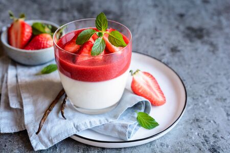 Traditional Panna cotta with strawberry sauce topping, served in a glass jarの写真素材
