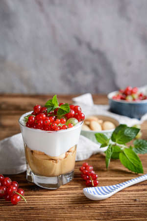 Refreshing summer cream cheese dessert with peanut butter and sponge biscuits, topped with fresh...