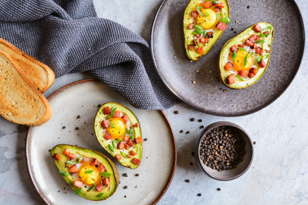 Roasted avocado egg boats with bacon and green onionの写真素材