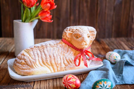 Classic Easter lamb pound cake sprinkled with powdered sugar on wooden background