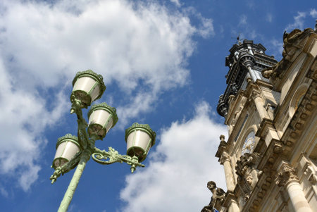 Streetlight in front of a monument over blue skyの写真素材