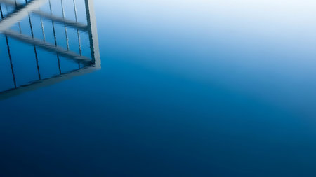 Reflection of a bridge in the water with a blue background.の素材