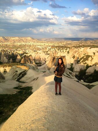 Woman with camera standing in Cappadocia landscape の素材