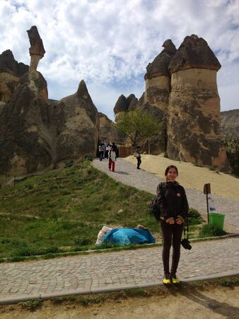Woman standing near the rock formation turkey の素材