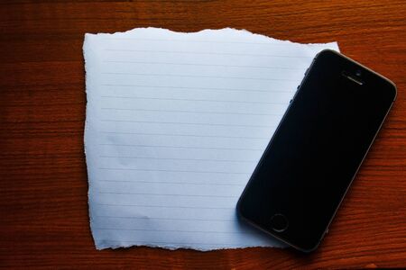 empty paper on the wooden with mobile phoneの写真素材