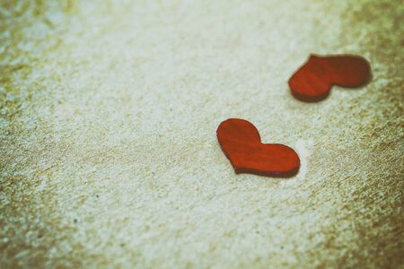 Red petal in heart shape on brown paper background in retro style