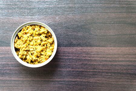 Stir Fried chicken with yellow curry paste(khaw-kling). Thai food in canned on wooden floor