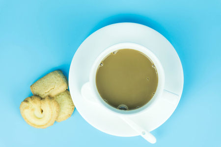 Coffee cup and candy on blue background.の写真素材