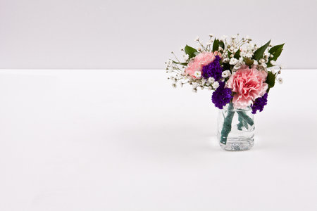 Bouquet of flowers in a glass vase on a white backgroundの写真素材