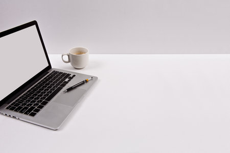 Laptop and cup of coffee on white background with copy space.の写真素材