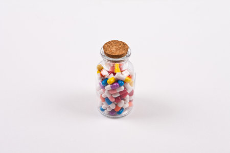Colorful pills in glass bottle on white background. Isolated.の写真素材