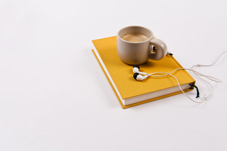 Cup of coffee, earphones and book isolated on white backgroundの写真素材
