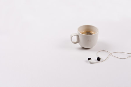 Cup of coffee and earphones on a white background. Isolatedの写真素材