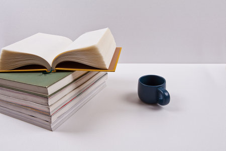 A stack of books and a cup of coffee on a white background